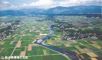 白川中流域の水田地帯。一番低い中央を掘り込んで流れるのが白川、奥は阿蘇外輪山方面、手前は熊本市方面。地形に沿って森林‐畑‐水田が段々に整然と配置されている。（写真：熊本県環境生活部）